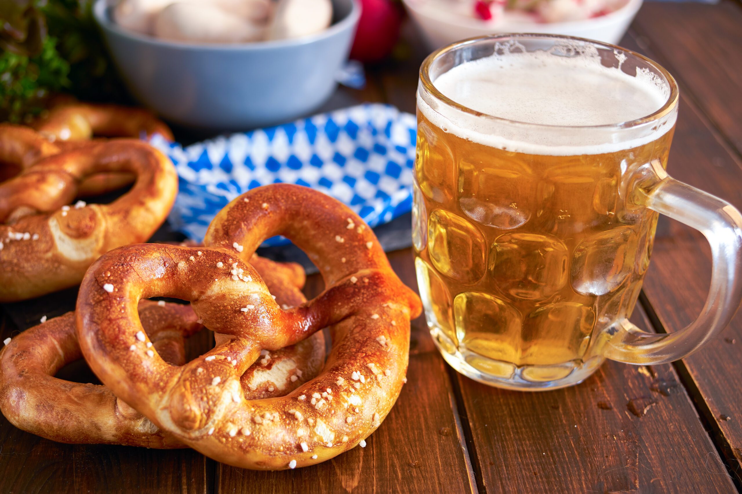 Soft pretzels and a glass of beer arranged for an Oktoberfest celebration.